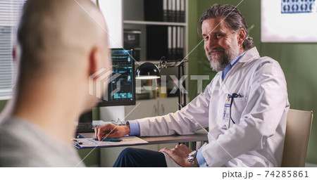 Oncologist telling good news to praying patient Oncologist telling good news to praying patient 74285861