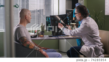 Doctor delivering bad news to patient during chemotherapy 74285954