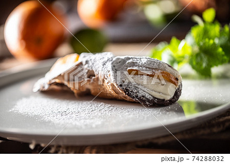 Sicilian Cannoli sweet dessert topped with sugar served on a plate 74288032