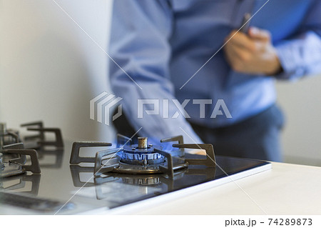 ガスコンロを点検する作業着の男性 74289873