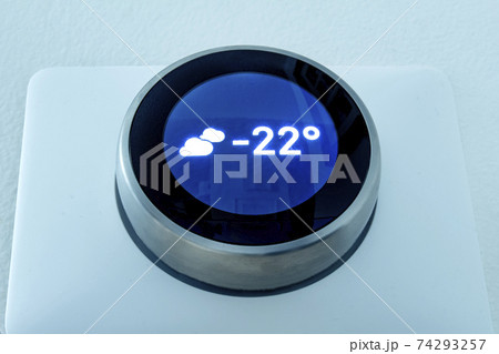 A Smart thermostat showing the outside weather temperature at night during winter. A Smart thermostat showing the outside weather temperature at night during winter. 74293257