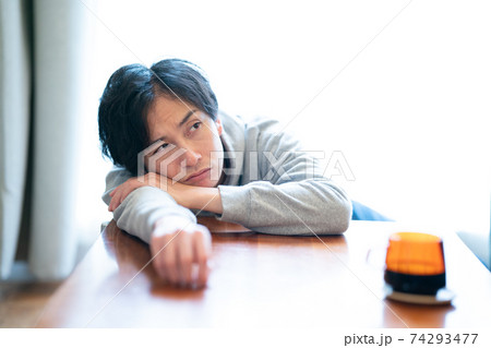 机に横たわる男性の写真素材