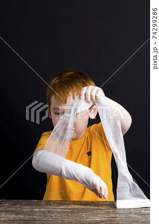 a beautiful boy with red hair with a damaged hand 74299286