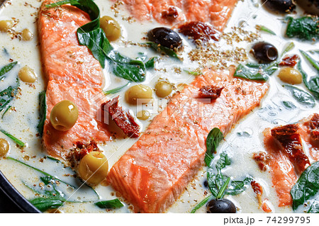 Tuscan salmon with cream sauce on a black dish 74299795