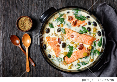 Tuscan salmon with cream sauce on a black dish 74299796