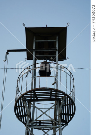 田舎の消防団を招集する火の見櫓の上に設けられた半鐘 74303072
