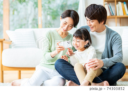 スマホで動画を見る若い家族 74303852