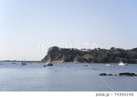 神奈川県三浦市江奈湾に浮かぶ釣り船と岩礁の風景 74304246
