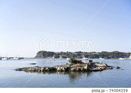 神奈川県三浦市江奈湾に浮かぶ釣り船と岩礁の風景 74304259