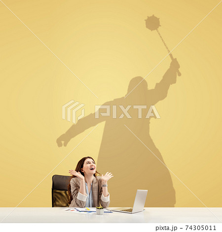 Young woman dreaming about fantasy worlds during her work in office. Becoming a legend. Shadow of dreams on the wall behind her. Copyspace. Young woman dreaming about fantasy worlds during her work in office. Becoming a legend. Shadow of dreams on the wall behind her. Copyspace. 74305011