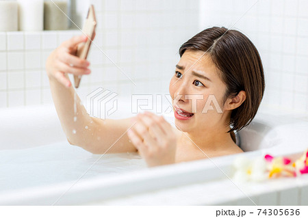 スマホを浴槽に落として水没させた女性 74305636