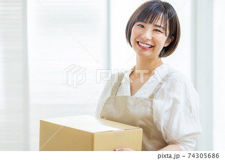 段ボールを持つ若い女性 74305686