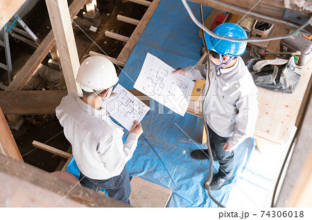 住宅建築現場で働く人々　スケルトンリフォーム　打ち合わせ　見下ろす 74306018