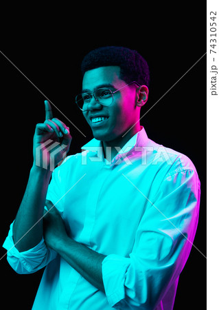 African-american man's portrait isolated on black studio background in multicolored neon light African-american man's portrait isolated on black studio background in multicolored neon light 74310542