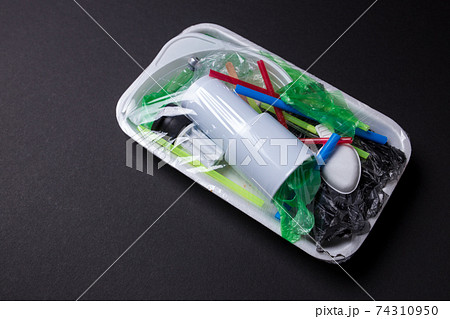 Set of plastic waste in a packed tray on a black isolated background. The problem of ecology and environmental pollution. Set of plastic waste in a packed tray on a black isolated background. The problem of ecology and environmental pollution. 74310950