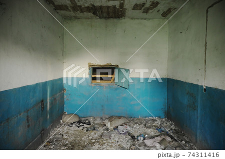 The appearance of the room of an abandoned building. Shabby walls. Torn wiring and rubbish on the floor. The appearance of the room of an abandoned building. Shabby walls. Torn wiring and rubbish on the floor. 74311416
