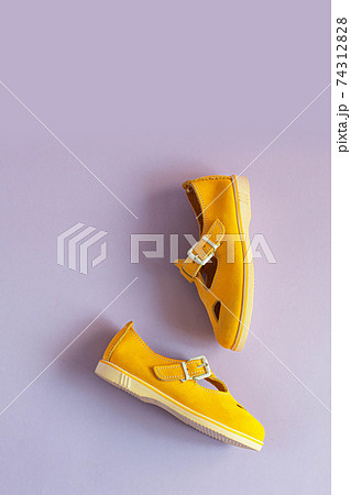 Women's summer yellow sandals on lilac background with copy space. Vertical photo Women's summer yellow sandals on lilac background with copy space. Vertical photo 74312828