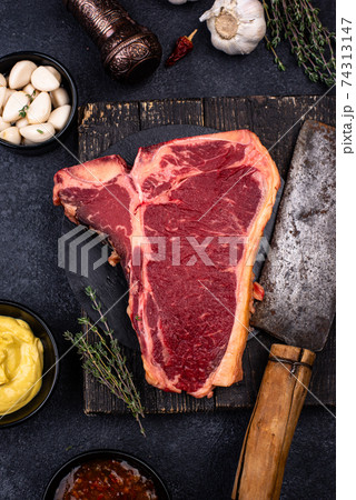 Raw uncooked T-bone steak with spices 74313147