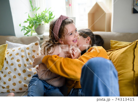 Sisters indoors at home, playing and having fun. Lockdown concept. 74313415