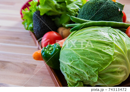 緑黄色野菜 木目背景クローズアップ素材の写真素材