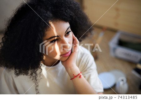 Close-up portrait of sad young woman indoors, resting. 74313485