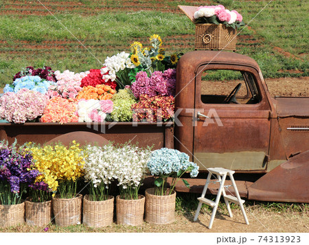 fake colorful flower in wicker basket decorating on vintage old car 74313923