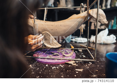 Portrait of young woman enjoying favorite job in workshop. Portrait of young woman enjoying favorite job in workshop. 74314110