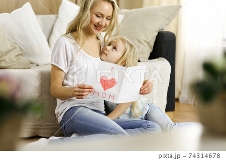 Happy mother day. Child daughter congratulates mom and gives her postcard with heart drawing. Family and childhood concepts Happy mother day. Child daughter congratulates mom and gives her postcard with heart drawing. Family and childhood concepts 74314678
