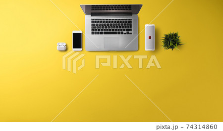 Flat lay top view office desk working space with laptop on yellow background. Copy space. 74314860