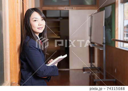 教科書を持って廊下に立っている女子高生 高校生 生徒 教科書を持って廊下に立っている女子高生 高校生 生徒 74315088