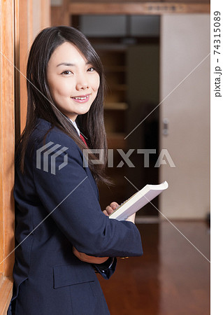 教科書を持って廊下に立っている女子高生 高校生 生徒 教科書を持って廊下に立っている女子高生 高校生 生徒 74315089