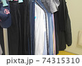 Unorganized clothes hanging on hangers 74315310