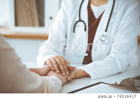 Hands of unknown woman-doctor reassuring her female patient, close-up. Medicine concept 74316417