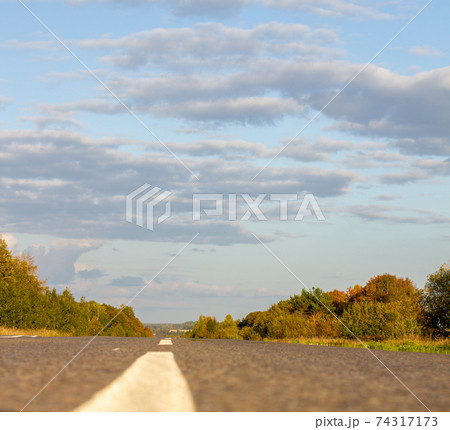 A long white stripe, like a road marker. A road between fields 74317173