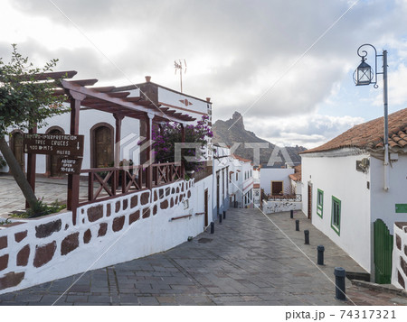 Tejeda, Gran Canaria, Canary Islands, Spain December 15, 2020: Steep narrow street in Tejeda Picturesque Canarian village at inland mountain valley caldera and Roque Bentayg rock 74317321