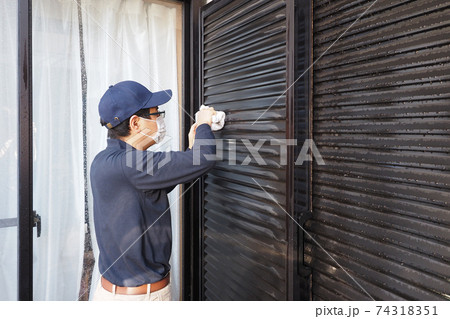 雨戸の掃除をするハウスクリーニングの男性作業員 74318351