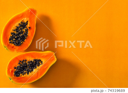 Papaya fruit orange color background Creative food sun shadow 74319689