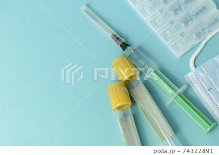 Medical vials for injection, syringe for injection, mask gloves on a blue background. Admission vaccination, flu shot. Medical vials for injection, syringe for injection, mask gloves on a blue background. Admission vaccination, flu shot. 74322891