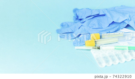 Medical vials for injection, syringe for injection, mask gloves on a blue background. Admission vaccination, flu shot. 74322910