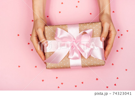 Beautiful female hand with packaged cute gift 74323041