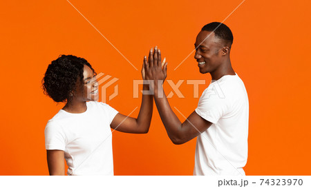 Joyful man and woman greeting each other with high five Joyful man and woman greeting each other with high five 74323970