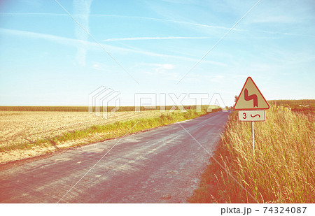 Retro toned picture of a countryside road at sunset, Poland. Retro toned picture of a countryside road at sunset, Poland. 74324087
