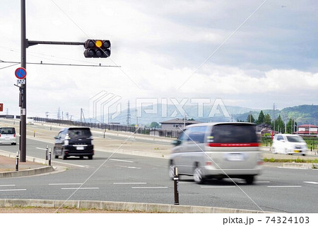 交差点に黄色信号で進入する車の写真素材