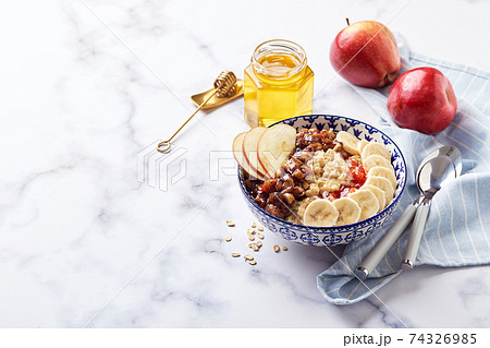 Homemade oatmeal for breakfast with apple, cinnamon and honey 74326985