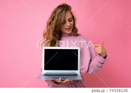 Shot of beautiful charming dark blond curly young feemale teenager lady lookind at netbook keyboard 74328126