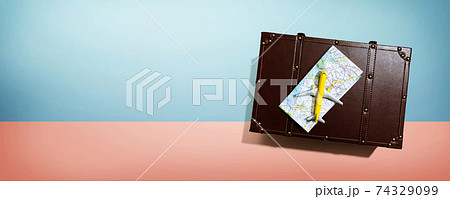 Travel theme with a miniature airplane and a suitcase Travel theme with a miniature airplane and a suitcase 74329099