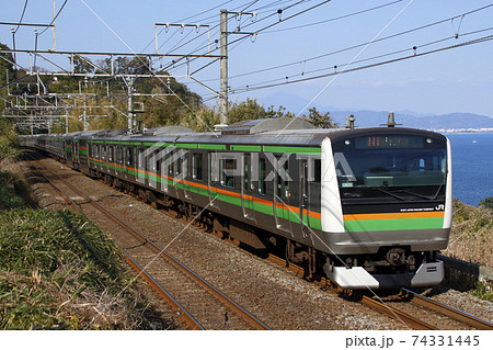 海沿いを行く東海道線E233系電車 74331445