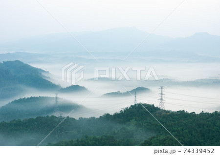 Electric transmission towers in fog Electric transmission towers in fog 74339452