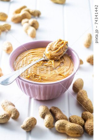 Peanut butter in bowl and peanuts Peanut butter in bowl and peanuts 74341442