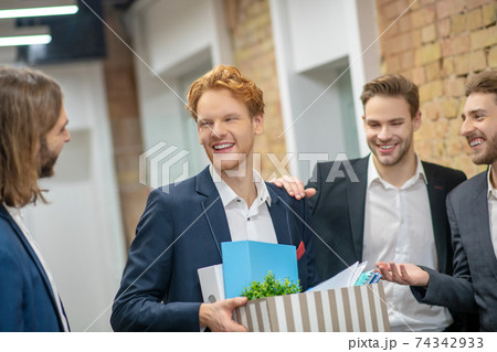 Joyful male colleagues communicating in the hallway Joyful male colleagues communicating in the hallway 74342933